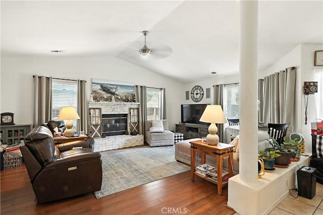 1115 Chennault Ave, Clovis, CA 93611 - living room with lofted ceiling, ceiling fan, healthy amount of natural light, a glass covered fireplace, and wood finished floors