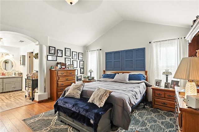 1115 Chennault Ave, Clovis, CA 93611 - bedroom featuring lofted ceiling, wood finished floors, arched walkways, multiple windows, and connected bathroom