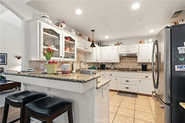 1115 Chennault Ave, Clovis, CA 93611 - kitchen featuring freestanding refrigerator, a peninsula, stone counters, tasteful backsplash, and recessed lighting