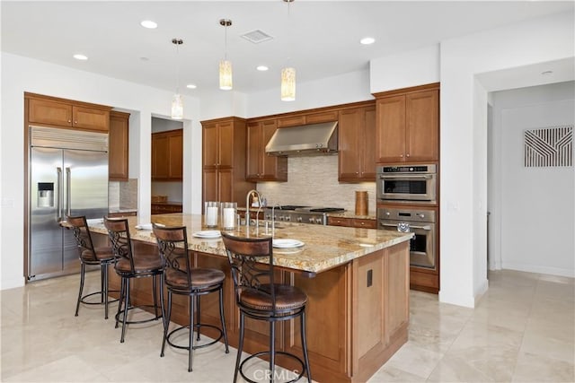 1278 Inspiration, West Covina, CA 91791 - kitchen with appliances with stainless steel finishes, wall chimney range hood, backsplash, brown cabinetry, and recessed lighting
