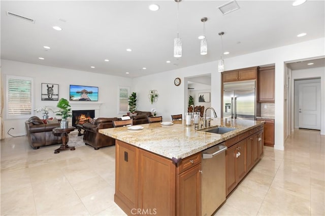 1278 Inspiration, West Covina, CA 91791 - kitchen featuring appliances with stainless steel finishes, a lit fireplace, recessed lighting, brown cabinets, and light stone counters