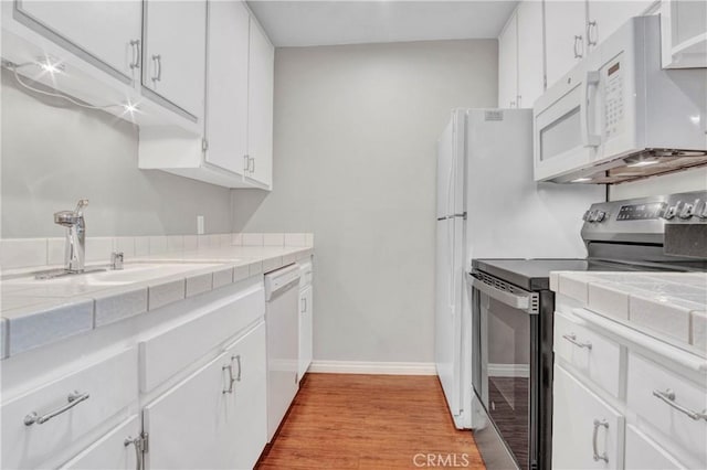 3603 W Hidden Ln Unit 210, Rolling Hills Estates, CA 90274 - kitchen featuring white appliances, tile countertops, light wood-style flooring, and white cabinetry
