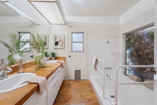 4241 Kingfisher Rd, Calabasas, CA 91302 - full bath with double vanity, stone finish flooring, healthy amount of natural light, and a bathtub
