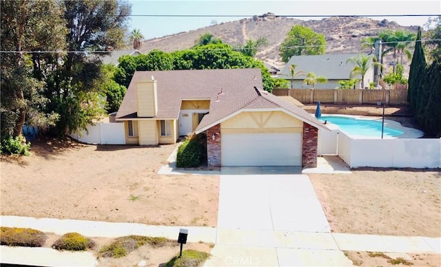 7707 Bolton Ave, Riverside, CA 92503 - view of front of house featuring concrete driveway, an attached garage, brick siding, and a mountain view