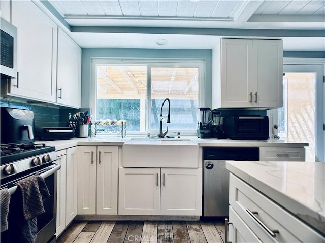 7707 Bolton Ave, Riverside, CA 92503 - kitchen featuring stainless steel appliances, light wood finished floors, tasteful backsplash, and white cabinetry