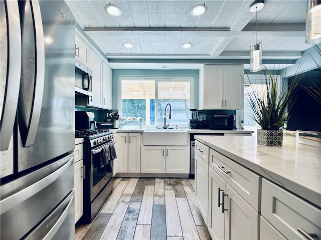7707 Bolton Ave, Riverside, CA 92503 - kitchen with appliances with stainless steel finishes, light wood-style floors, white cabinetry, light stone countertops, and decorative light fixtures