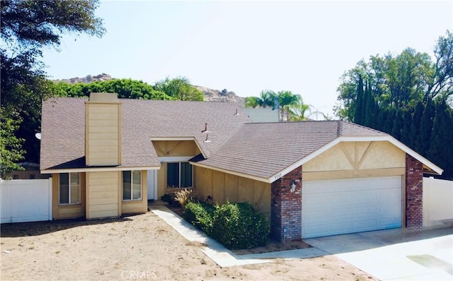 7707 Bolton Ave, Riverside, CA 92503 - view of front of house with driveway, a garage, a chimney, brick siding, and a shingled roof