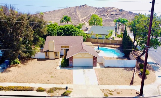 7707 Bolton Ave, Riverside, CA 92503 - view of front facade featuring concrete driveway, an attached garage, a mountain view, and brick siding