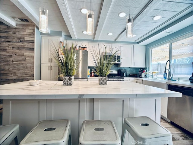 7707 Bolton Ave, Riverside, CA 92503 - kitchen with dishwasher, white cabinets, light stone counters, hanging light fixtures, and a wooden ceiling with exposed beams