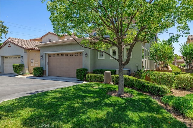 23785 Western Cedar Ct, Valencia, CA 91354 - mediterranean / spanish-style house featuring stucco siding, a front yard, a tile roof, and an attached garage