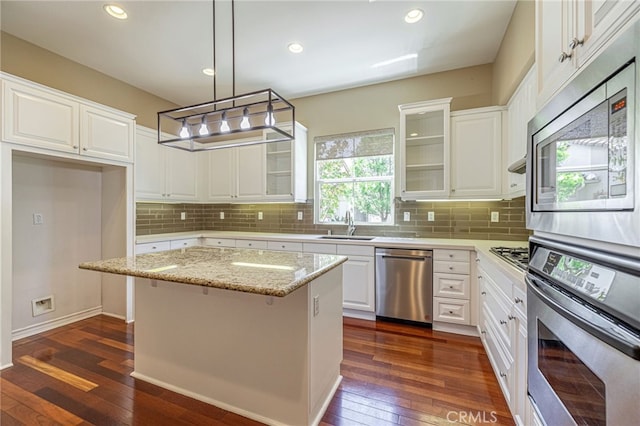 23785 Western Cedar Ct, Valencia, CA 91354 - kitchen featuring appliances with stainless steel finishes, dark wood-style flooring, glass insert cabinets, tasteful backsplash, and recessed lighting