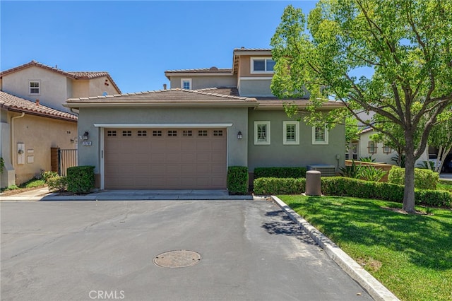 23785 Western Cedar Ct, Valencia, CA 91354 - view of front facade with an attached garage, stucco siding, asphalt driveway, a front lawn, and a tile roof