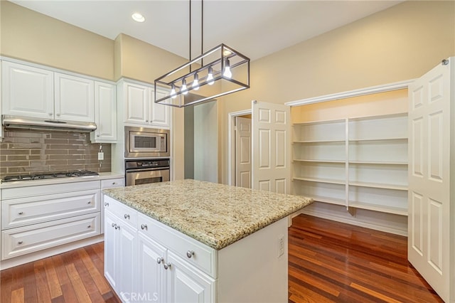 23785 Western Cedar Ct, Valencia, CA 91354 - kitchen featuring appliances with stainless steel finishes, a chandelier, under cabinet range hood, tasteful backsplash, and light stone counters