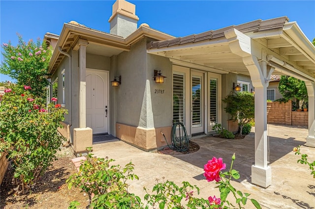 23785 Western Cedar Ct, Valencia, CA 91354 - view of front of house featuring stucco siding, a chimney, and a patio area