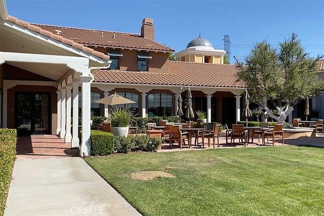 23785 Western Cedar Ct, Valencia, CA 91354 - rear view of house featuring a tile roof, a chimney, a lawn, and a patio