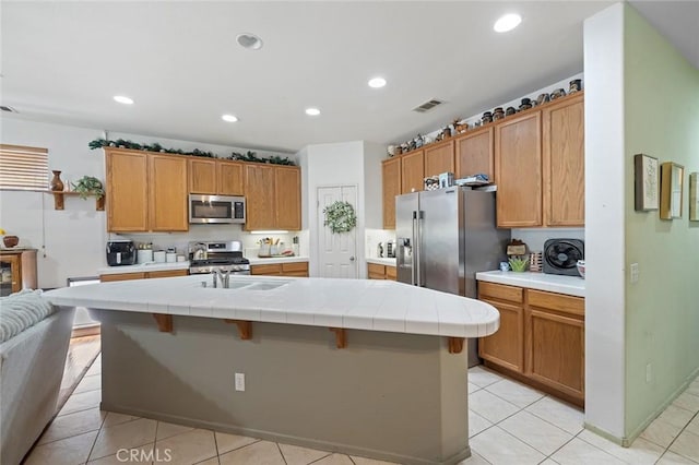 34722 Fairport Way, Yucaipa, CA 92399 - kitchen with stainless steel appliances, light tile patterned flooring, a kitchen island with sink, tile countertops, and recessed lighting
