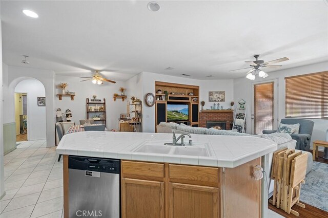34722 Fairport Way, Yucaipa, CA 92399 - kitchen with dishwasher, ceiling fan, open floor plan, a brick fireplace, and arched walkways