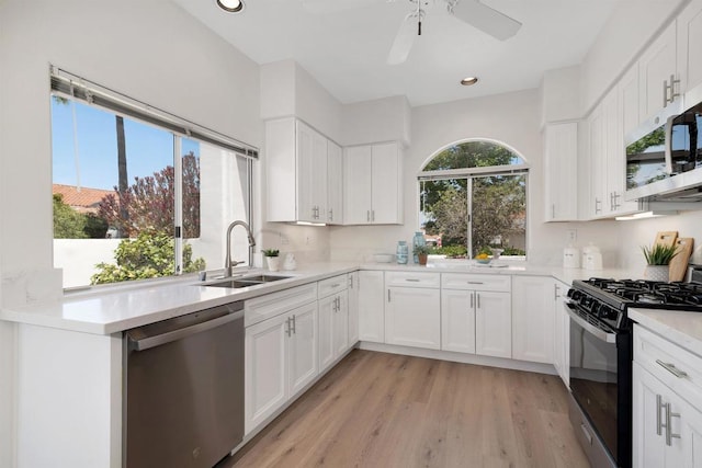 4981 Lerkas Way, Oceanside, CA 92056 - kitchen with appliances with stainless steel finishes, white cabinetry, light countertops, recessed lighting, and light wood-type flooring