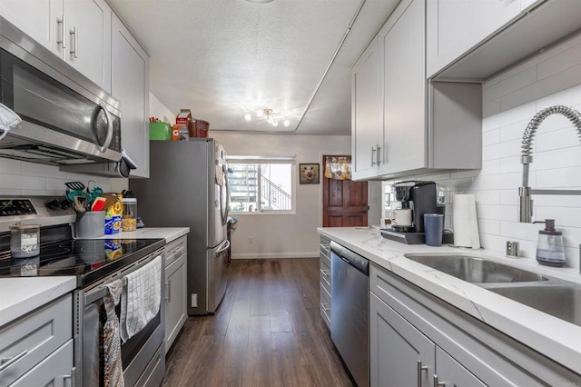 2041 E Grand Ave Unit 19, Escondido, CA 92027 - kitchen featuring appliances with stainless steel finishes, tasteful backsplash, dark wood finished floors, light stone counters, and a textured ceiling