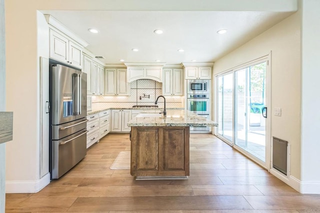 15716 Milne Cir, Moorpark, CA 93021 - kitchen with appliances with stainless steel finishes, light wood finished floors, light stone counters, decorative backsplash, and recessed lighting