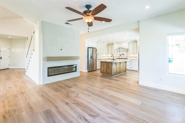 15716 Milne Cir, Moorpark, CA 93021 - unfurnished living room featuring a ceiling fan, light wood-style flooring, a glass covered fireplace, recessed lighting, and stairway