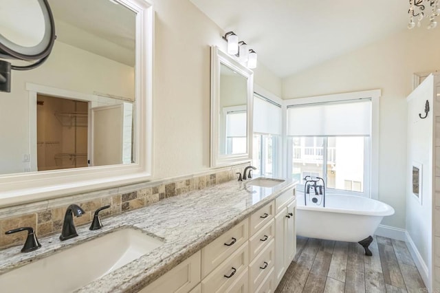 15716 Milne Cir, Moorpark, CA 93021 - bathroom featuring wood finished floors, double vanity, a soaking tub, lofted ceiling, and a spacious closet