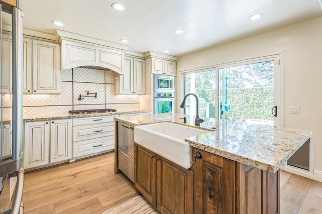 15716 Milne Cir, Moorpark, CA 93021 - kitchen featuring stainless steel appliances, light wood-type flooring, tasteful backsplash, light stone counters, and recessed lighting