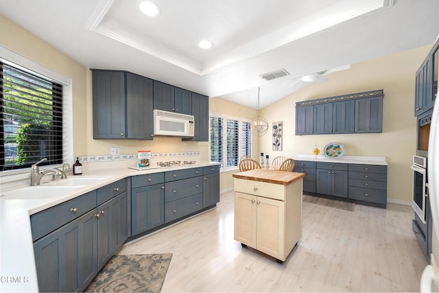 6357 Irena Ave, Camarillo, CA 93012 - kitchen featuring wood counters, white microwave, light wood-style flooring, stainless steel oven, and a tray ceiling