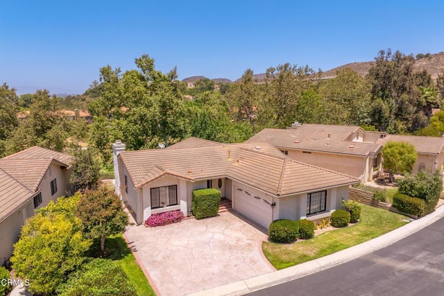 6357 Irena Ave, Camarillo, CA 93012 - mediterranean / spanish-style home featuring a tile roof, an attached garage, stucco siding, a chimney, and driveway