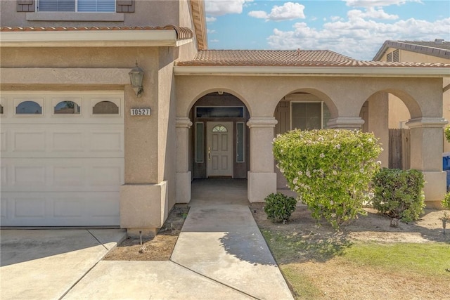 10527 Rose River Falls Ave, Bakersfield, CA 93312 - doorway to property featuring a tiled roof, stucco siding, and concrete driveway
