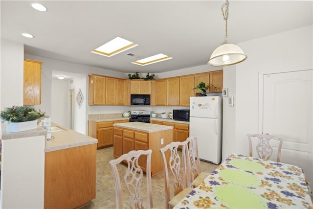 10527 Rose River Falls Ave, Bakersfield, CA 93312 - kitchen with freestanding refrigerator, stove, black microwave, recessed lighting, and a kitchen island