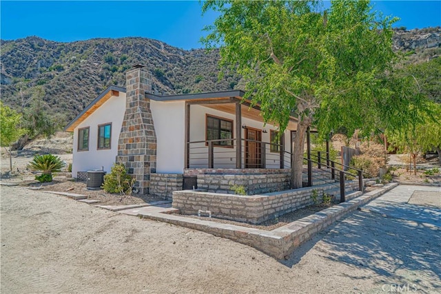 29701 Jackson St, Castaic, CA 91384 - view of front of home with a mountain view, stucco siding, a chimney, and covered porch