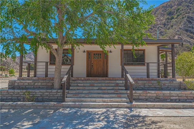 29701 Jackson St, Castaic, CA 91384 - view of front facade with a porch, stucco siding, and a mountain view