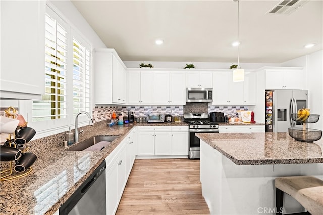 27555 Mountainside St, Menifee, CA 92584 - kitchen featuring stainless steel appliances, light wood-style flooring, white cabinets, light stone counters, and recessed lighting