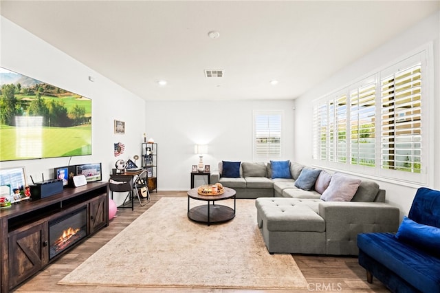 27555 Mountainside St, Menifee, CA 92584 - living area with light wood-type flooring, a glass covered fireplace, and recessed lighting