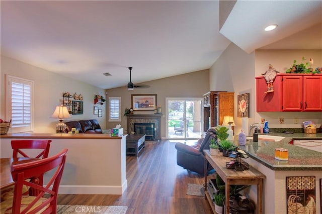 1320 Fairway Dr, Atwater, CA 95301 - kitchen featuring open floor plan, ceiling fan, a glass covered fireplace, wood finished floors, and vaulted ceiling