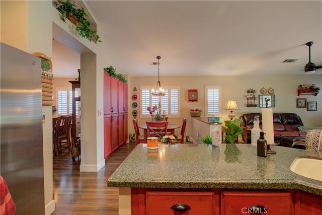 1320 Fairway Dr, Atwater, CA 95301 - kitchen with freestanding refrigerator, dark wood-style flooring, open floor plan, a chandelier, and pendant lighting