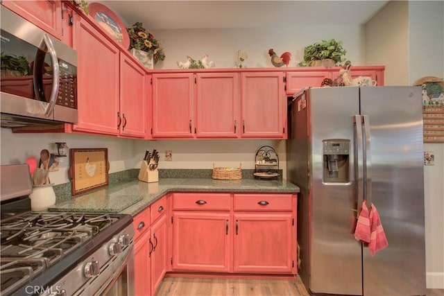 1320 Fairway Dr, Atwater, CA 95301 - kitchen with appliances with stainless steel finishes, light wood-style flooring, and dark stone countertops