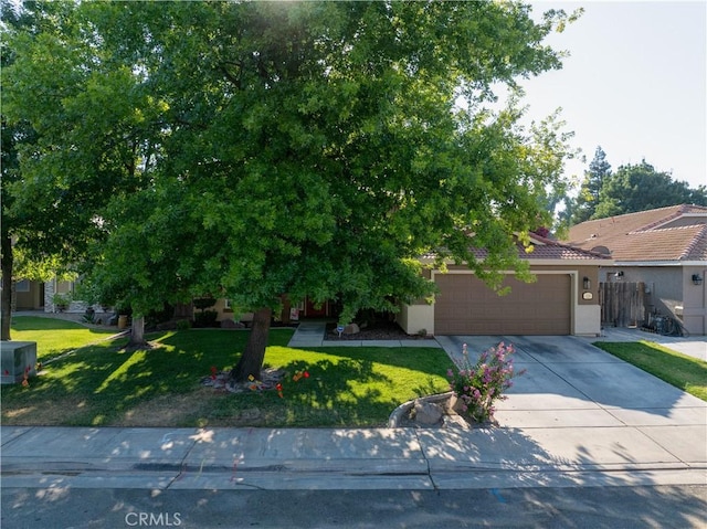 1320 Fairway Dr, Atwater, CA 95301 - view of property hidden behind natural elements featuring a garage, stucco siding, driveway, and a tiled roof