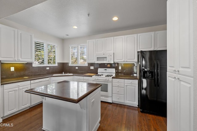 104 W Santa Clara St, Ventura, CA 93001 - kitchen featuring white appliances, dark countertops, white cabinetry, dark wood-type flooring, and recessed lighting