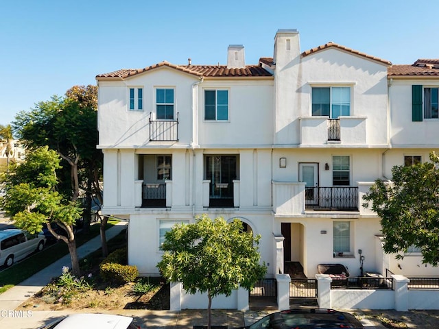 104 W Santa Clara St, Ventura, CA 93001 - view of front of property featuring a balcony, a tile roof, a fenced front yard, and stucco siding
