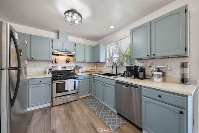 4742 Pauline Pl, Kelseyville, CA 95451 - kitchen with appliances with stainless steel finishes, under cabinet range hood, wood finished floors, light countertops, and recessed lighting