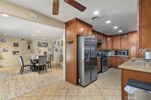 5228 N G St, San Bernardino, CA 92407 - kitchen with appliances with stainless steel finishes, ceiling fan, recessed lighting, brown cabinetry, and light stone countertops