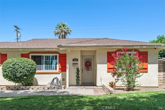 5228 N G St, San Bernardino, CA 92407 - view of front of house featuring stucco siding, a front lawn, and a shingled roof