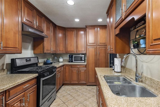 5228 N G St, San Bernardino, CA 92407 - kitchen with stainless steel appliances, under cabinet range hood, recessed lighting, light tile patterned flooring, and brown cabinets