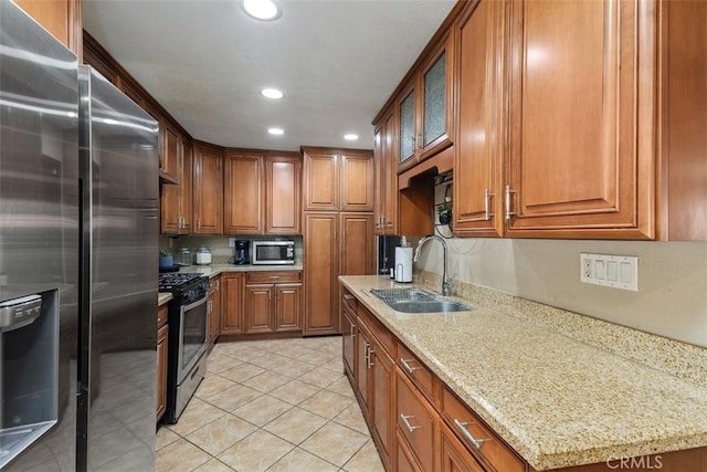 5228 N G St, San Bernardino, CA 92407 - kitchen with stainless steel appliances, brown cabinetry, recessed lighting, and light stone counters