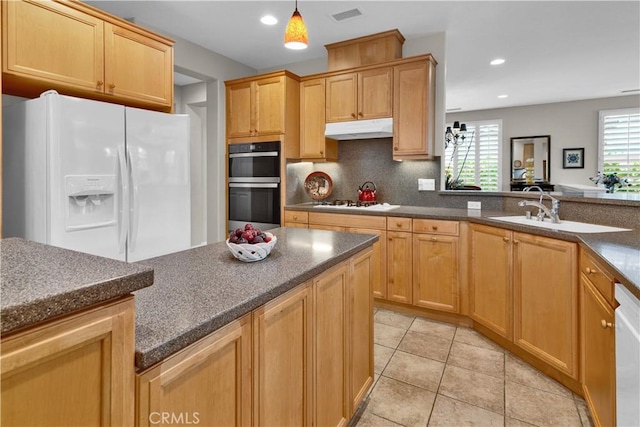 2757 Traditions, Paso Robles, CA 93446 - kitchen featuring white appliances, under cabinet range hood, light tile patterned flooring, decorative backsplash, and hanging light fixtures