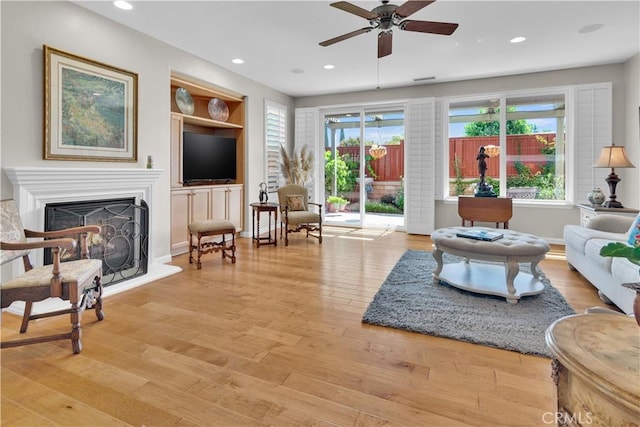 2757 Traditions, Paso Robles, CA 93446 - living room featuring a ceiling fan, light wood-style floors, a fireplace with raised hearth, built in shelves, and recessed lighting