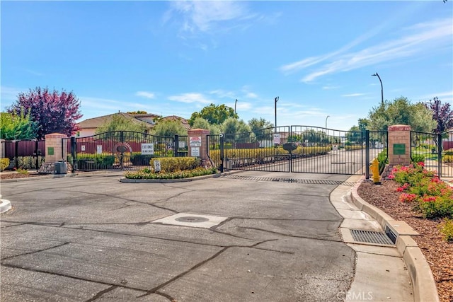 2757 Traditions, Paso Robles, CA 93446 - view of asphalt street featuring a gate, a gated entry, curbs, and street lights