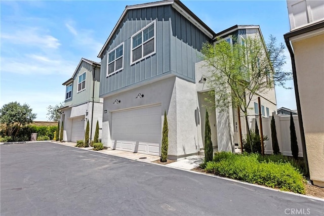 4408 S Grant Paseo, Ontario, CA 91762 - view of front of house with board and batten siding, a garage, and stucco siding